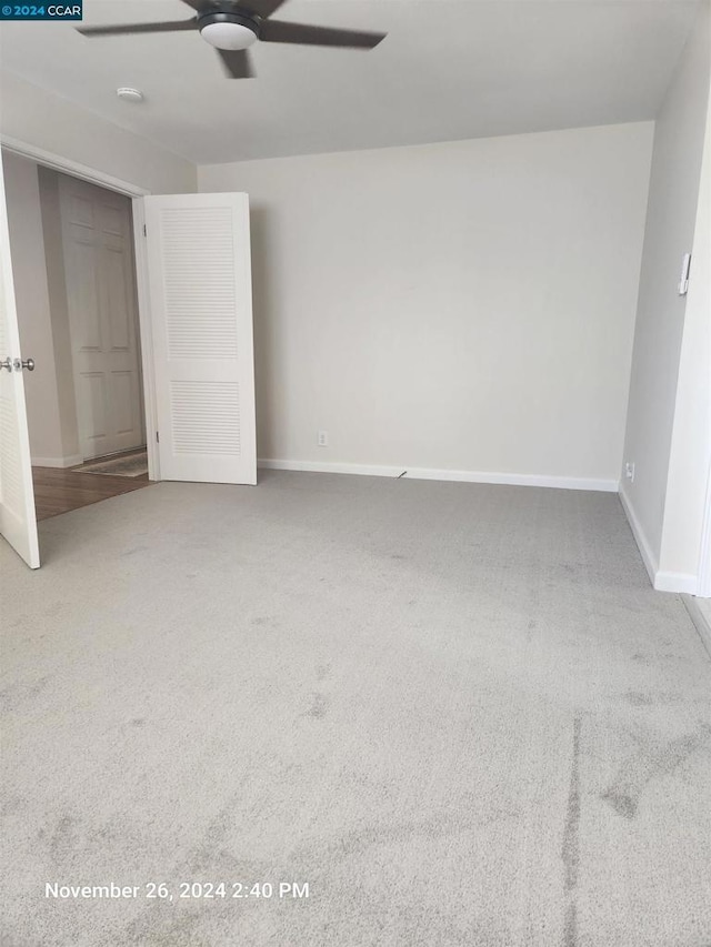 carpeted spare room featuring ceiling fan