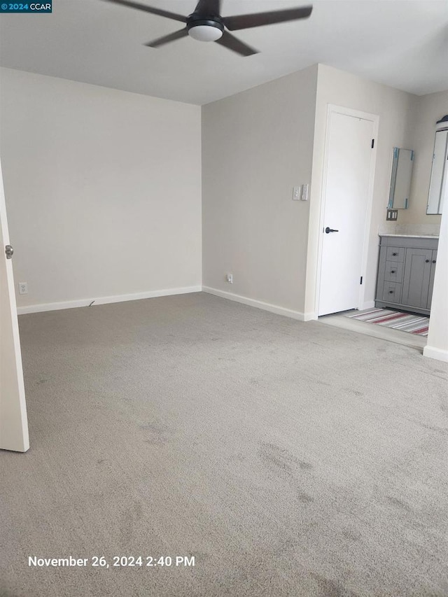 spare room featuring light carpet and ceiling fan