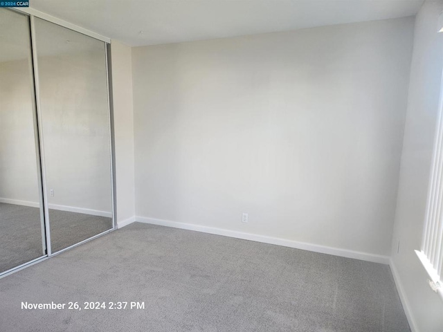 unfurnished bedroom featuring carpet flooring and a closet