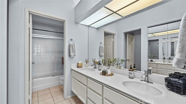 full bathroom with tile patterned floors, vanity, bath / shower combo with glass door, and toilet