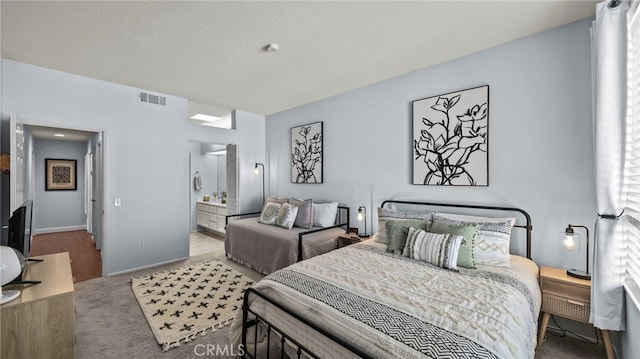 bedroom featuring carpet, a textured ceiling, and connected bathroom