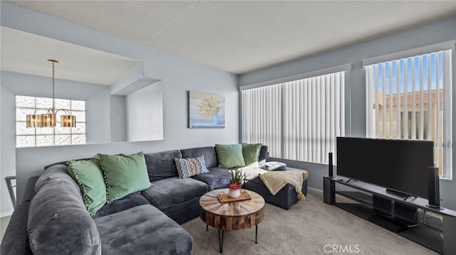 carpeted living room featuring a chandelier, a textured ceiling, and a healthy amount of sunlight