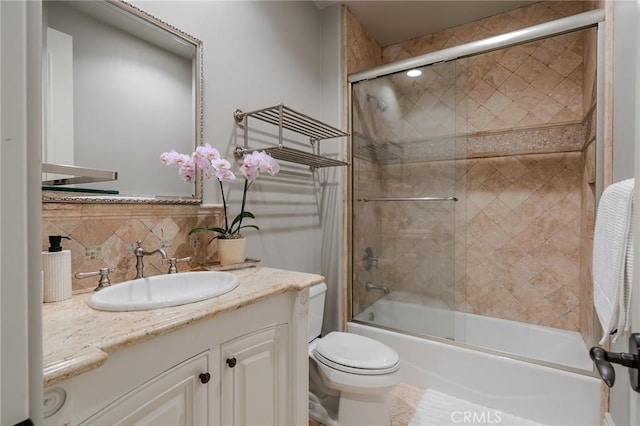 full bathroom with shower / bath combination with glass door, vanity, toilet, and backsplash