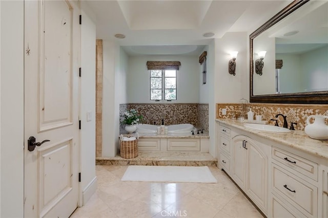 bathroom featuring tile patterned flooring, a bath, vanity, and a raised ceiling