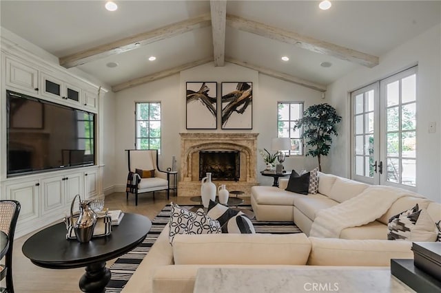 living room with a high end fireplace, french doors, lofted ceiling with beams, and a wealth of natural light