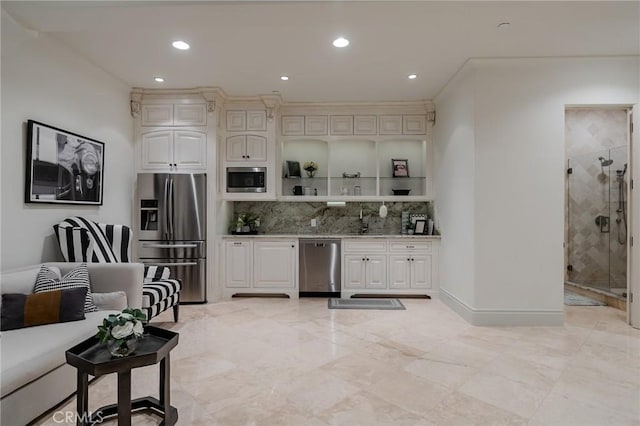 kitchen with light stone countertops, sink, appliances with stainless steel finishes, and tasteful backsplash