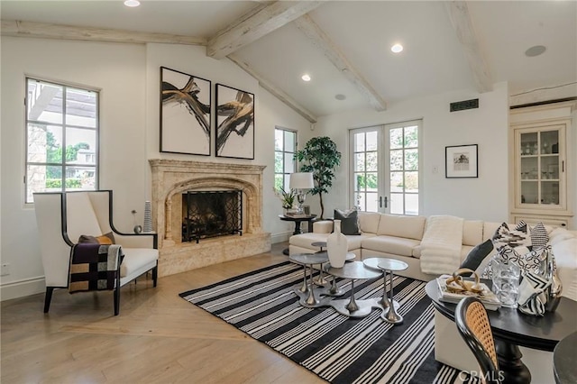 living room with light wood-type flooring, lofted ceiling with beams, a healthy amount of sunlight, and a premium fireplace