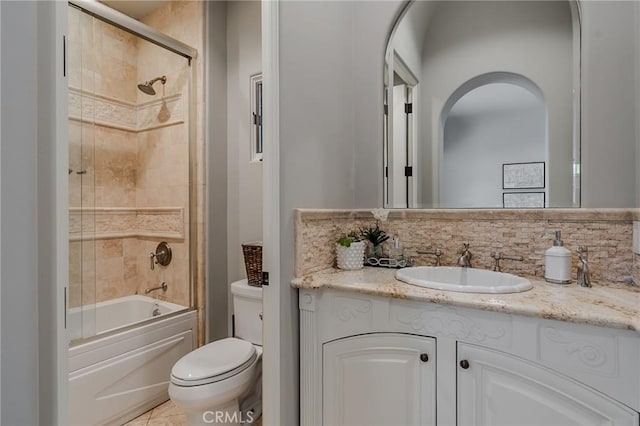 full bathroom featuring vanity, toilet, shower / bath combination with glass door, and tasteful backsplash