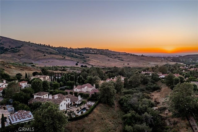 aerial view at dusk featuring a mountain view