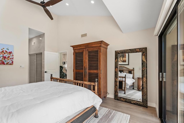 bedroom with ceiling fan, a closet, high vaulted ceiling, and light hardwood / wood-style flooring