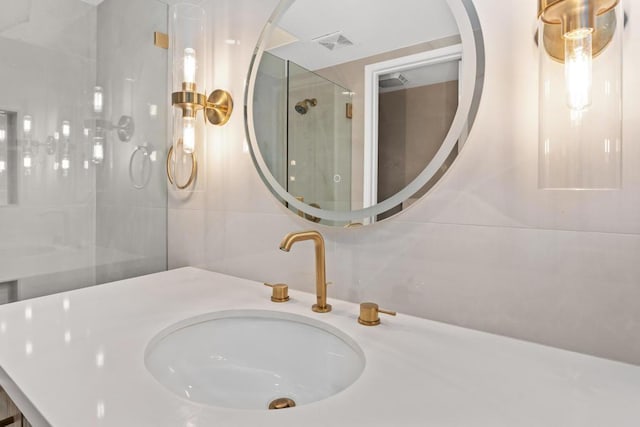 bathroom featuring a tile shower, tile walls, and sink