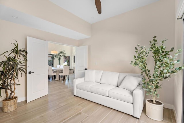 living room with ceiling fan and light wood-type flooring