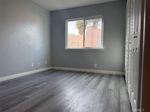 unfurnished room featuring dark wood-type flooring