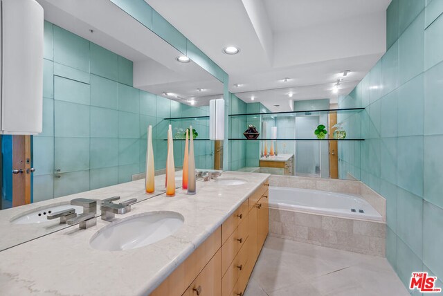 bathroom with vanity, tile patterned floors, tile walls, and independent shower and bath