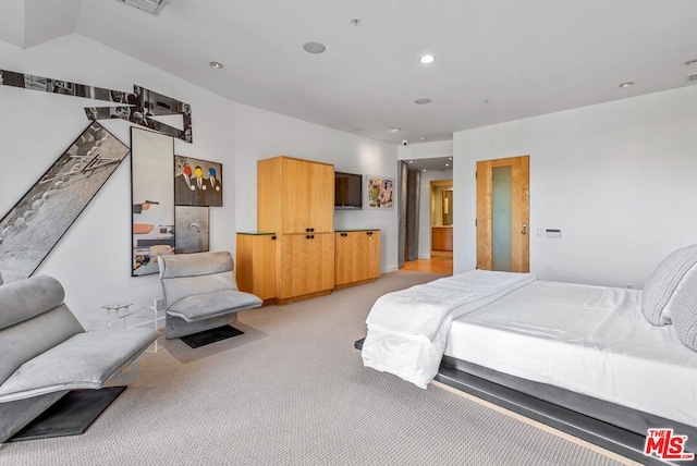 bedroom featuring light carpet and vaulted ceiling