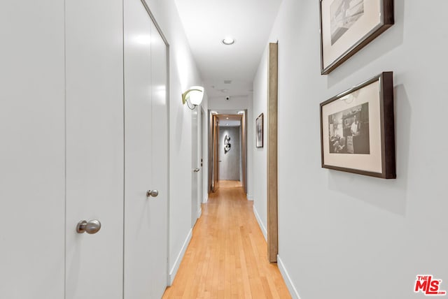 corridor with light hardwood / wood-style floors