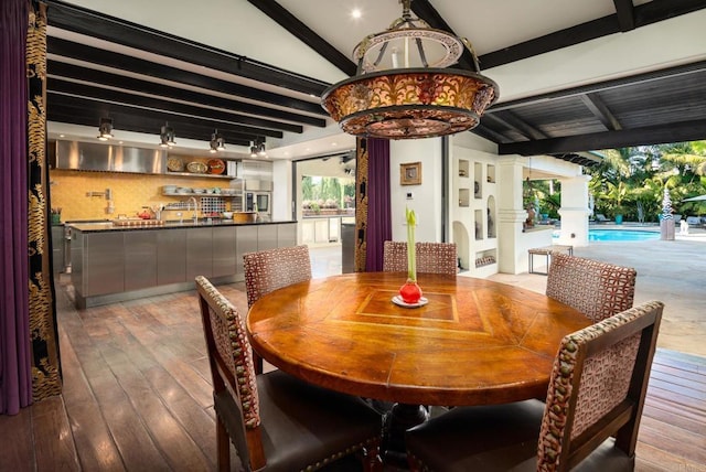 dining room with wood-type flooring and lofted ceiling with beams