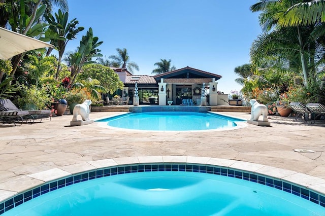 view of swimming pool featuring an in ground hot tub and a patio area