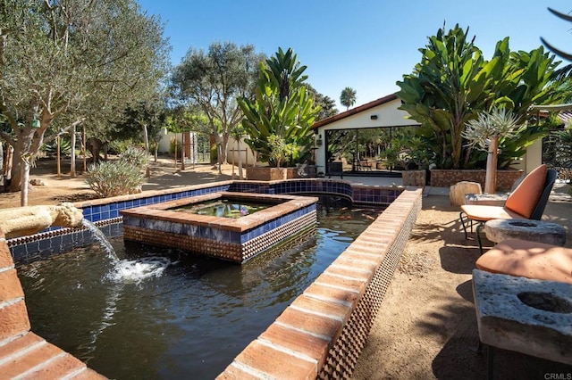 view of pool with an in ground hot tub and pool water feature