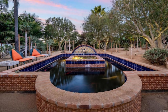 pool at dusk featuring a grill