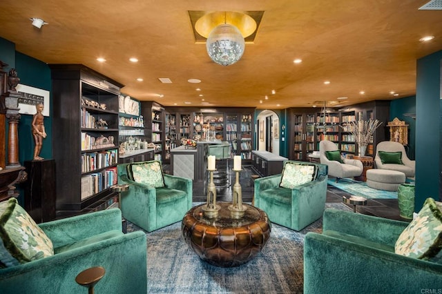 sitting room featuring arched walkways and recessed lighting