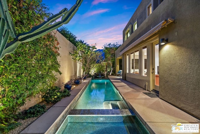 view of pool at dusk