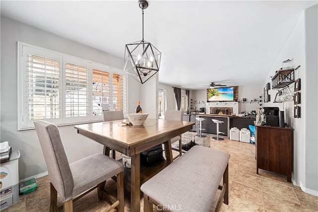 dining space featuring ceiling fan with notable chandelier