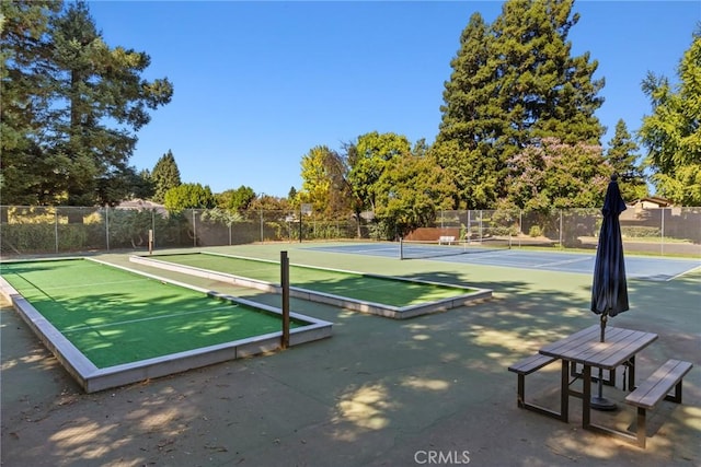 view of home's community featuring tennis court