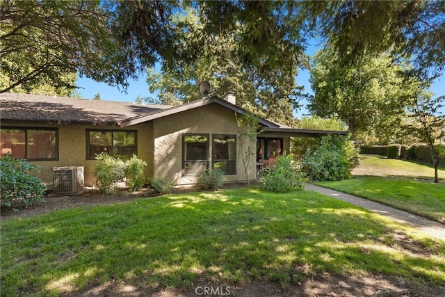 ranch-style home with cooling unit and a front yard