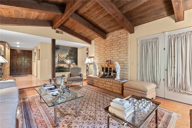 living room featuring light wood-type flooring, vaulted ceiling with beams, a brick fireplace, and wooden ceiling