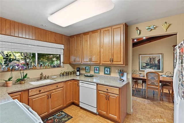 kitchen featuring dishwasher, light stone countertops, sink, and light parquet floors