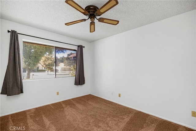 spare room featuring baseboards, ceiling fan, carpet, and a textured ceiling