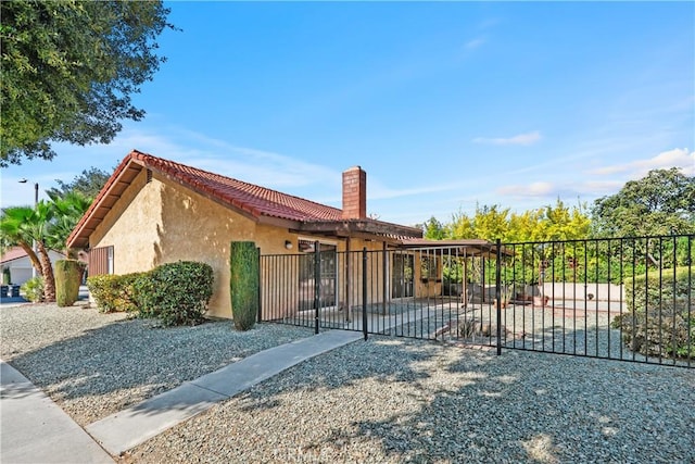 view of front of property with stucco siding, fence, and a chimney