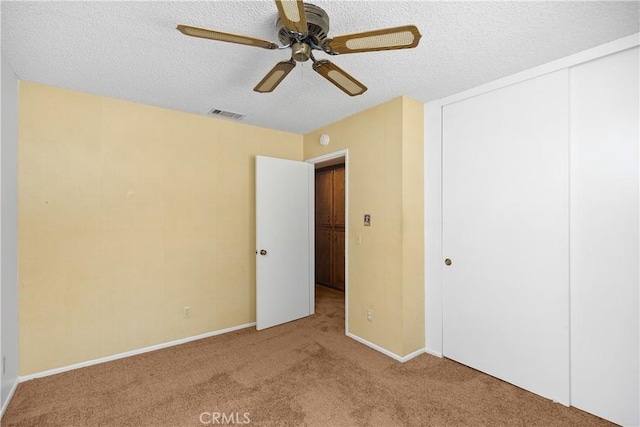 unfurnished bedroom with a closet, a textured ceiling, visible vents, and carpet