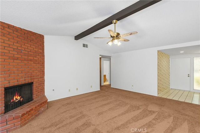 unfurnished living room featuring ceiling fan, carpet flooring, a fireplace, and lofted ceiling with beams