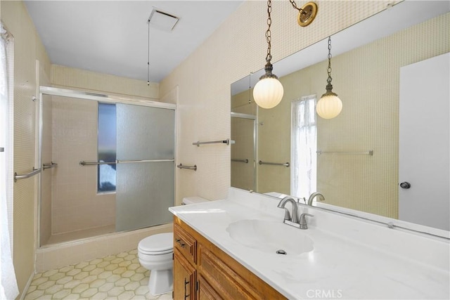 full bath featuring a shower with door, visible vents, toilet, and vanity