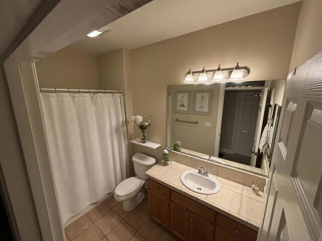 bathroom with tile patterned flooring, vanity, and toilet