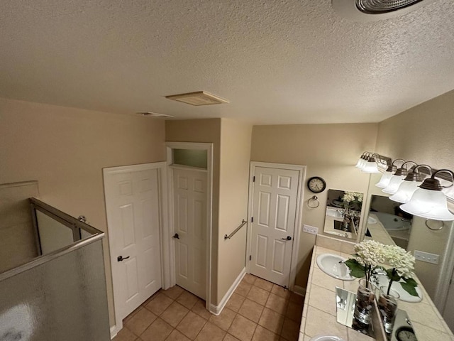 bathroom with vanity, a textured ceiling, and tile patterned floors