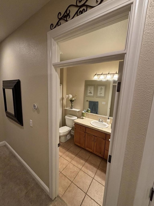 bathroom featuring tile patterned floors, vanity, and toilet