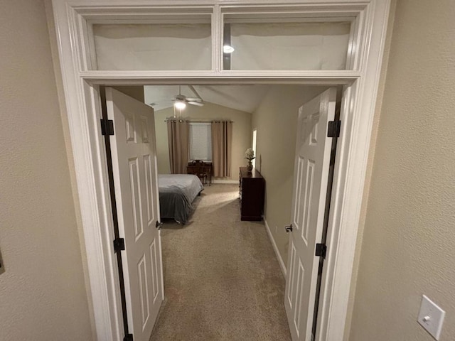 hallway with carpet flooring and vaulted ceiling