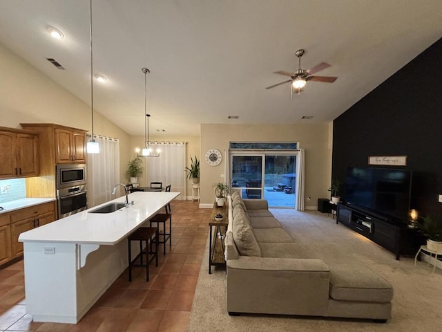 tiled living room featuring sink, ceiling fan with notable chandelier, and lofted ceiling