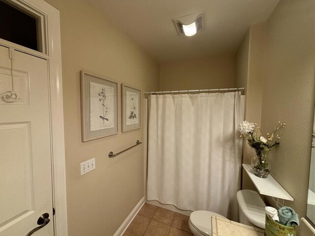 bathroom with toilet and tile patterned floors