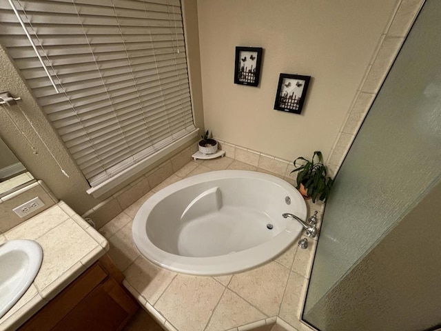 bathroom with tiled tub and vanity