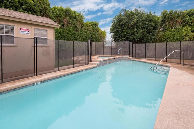 view of swimming pool featuring an in ground hot tub