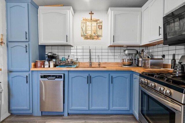 kitchen featuring decorative backsplash, hardwood / wood-style floors, stainless steel appliances, and white cabinetry