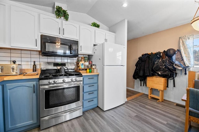 kitchen featuring backsplash, gas stove, white refrigerator, white cabinets, and light hardwood / wood-style floors