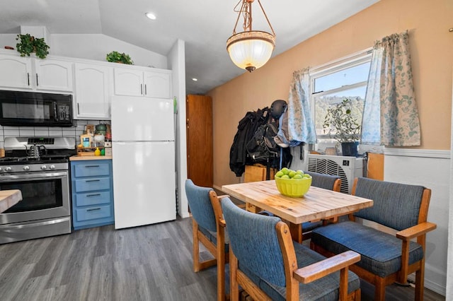 kitchen with white cabinetry, backsplash, white fridge, pendant lighting, and stainless steel stove