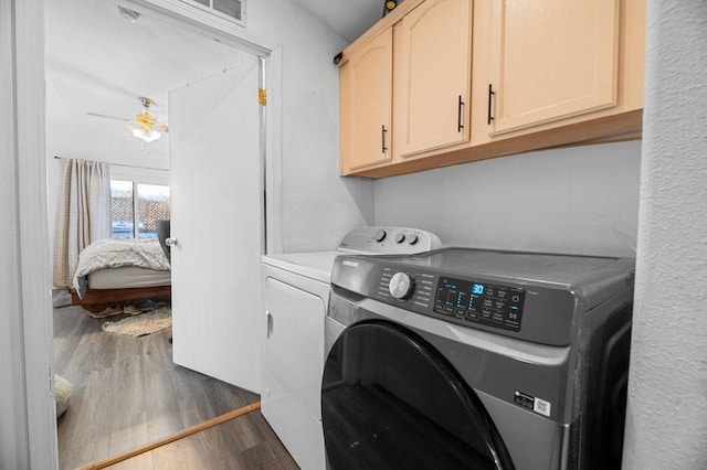 laundry area featuring cabinets, ceiling fan, washer and dryer, and dark hardwood / wood-style floors