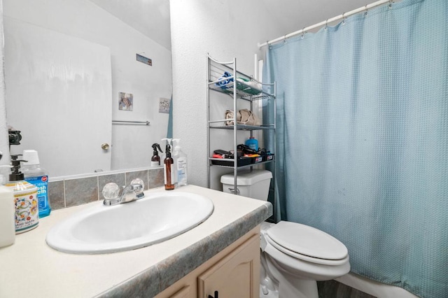 bathroom featuring curtained shower, vanity, and toilet