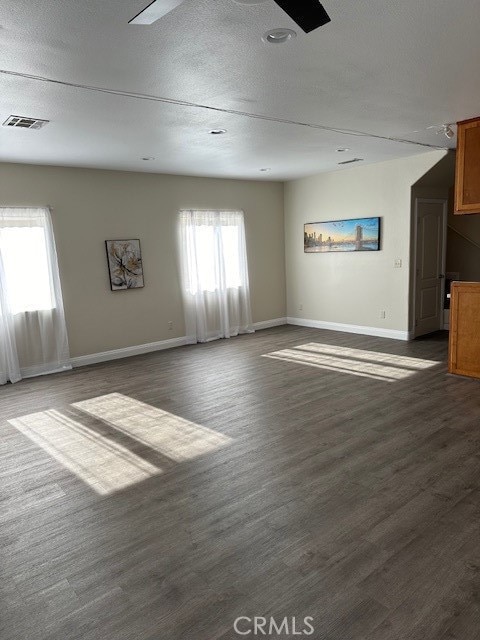 unfurnished living room featuring dark hardwood / wood-style floors and a textured ceiling